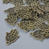 Furnitură pentru pandantiv «Hamsa», diametru 21×15 mm, diametrul găurii 1,7 mm, ambalaj 24 buc. ±, culoare bronz metalic