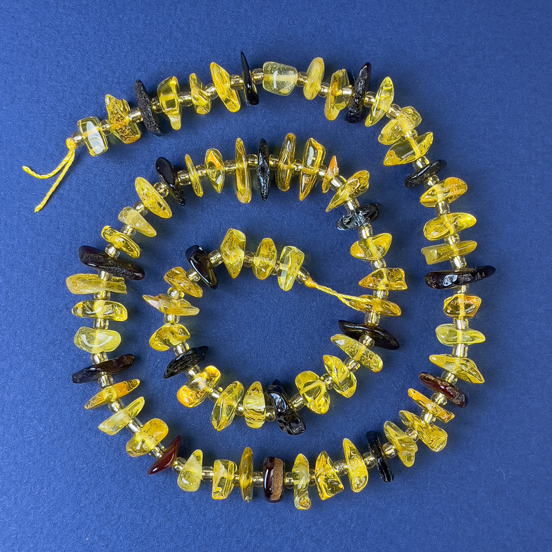 Mărgele din chihlimbar – fragmente de 10–12×4 mm, cu mărgele, pe șnur, lungime 38 cm