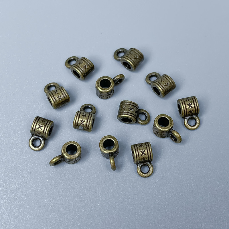 Furnitură bail, culoare bronz, dimensiuni 9x5x5 mm +/-; găuri cu diametrul aproximativ 2,5 mm și 2 mm; ambalare 34 buc