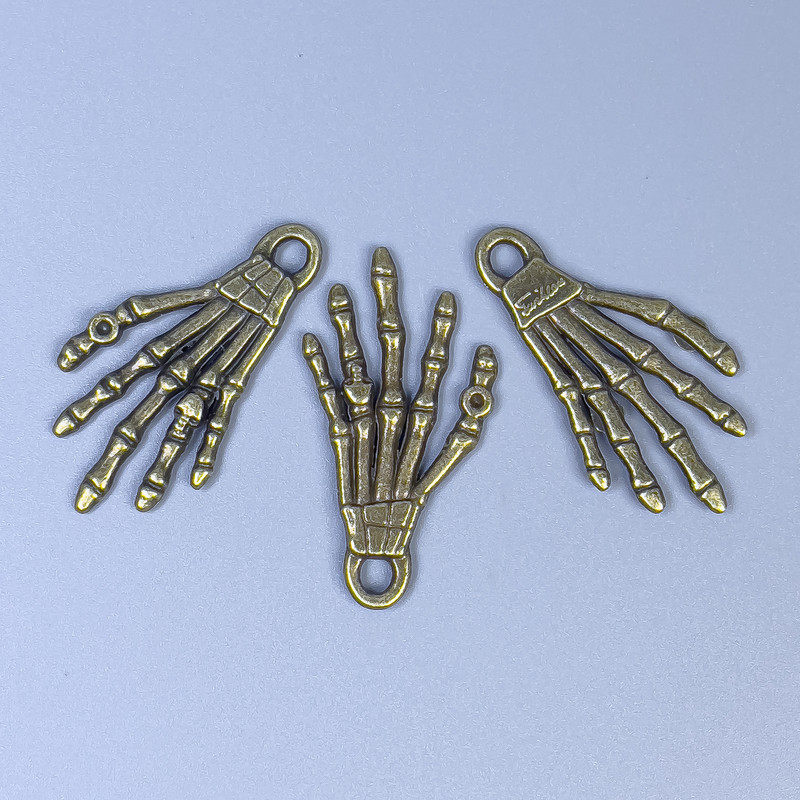 Pandantiv mână de schelet, culoare bronz, dimensiuni 35x19x2 mm, gaură de 3 mm, ambalaj 20 g (~9 buc.)