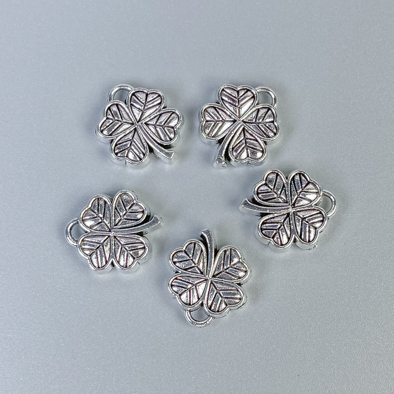Furnitură bail – inserție pandantiv trifoi, culoare argintiu metalic, dimensiuni 13x16x4 mm +/-; găuri diametru 1,5 mm +/-; diametrul 1 mm +/-; ambalaj 20 g