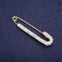 Broșă cu ac cu strasuri albe 75×16 mm +/- metal auriu