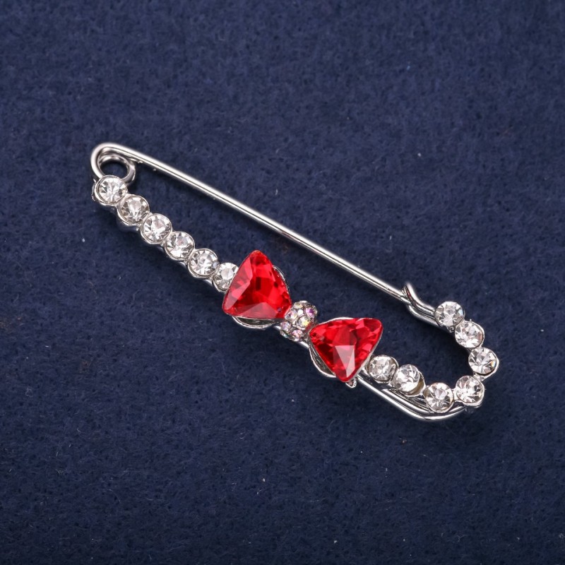 Broșă cu ac în formă de fundă, cu strasuri albe, culoare pietrelor roșii, 64×18 mm, metal argintiu