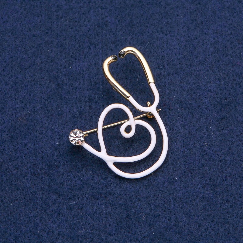 Broșă «Stetoscop alb cu inimă», piatră albă, metal auriu, 43×33 mm