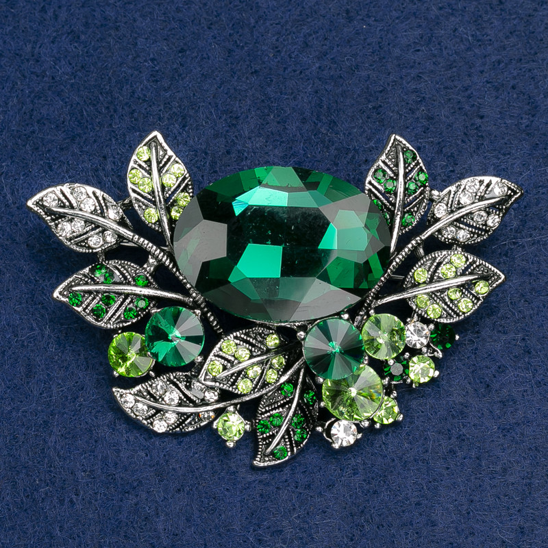 Broșă mare «Accent» în design vegetal cu strasuri și piatră de culoare verde închis și albă, metal argintiu, 67×46 mm