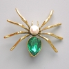 Broșă-pendulă în formă de păianjen «Păianjen» cu cristal verde, mărgea albă, metal auriu 45×39 mm