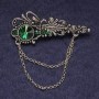 Broșă «Accent» cu strasuri verzi și cristal, metal argintiu 55x22 mm